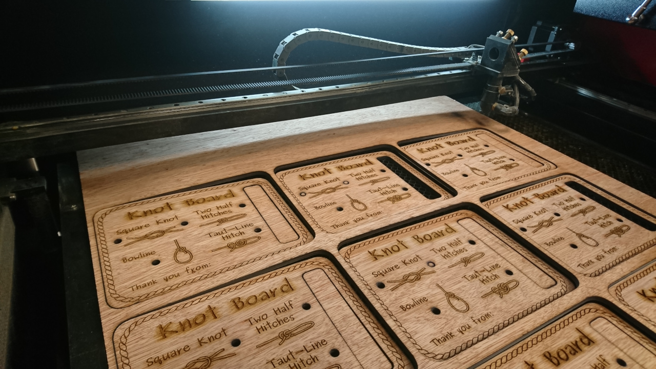 Cut knot boards sitting the bed of the laser cutter